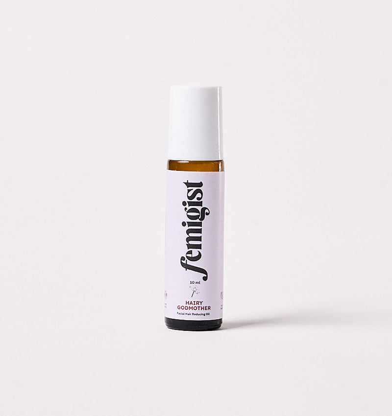 10ml roller bottle of Hairy Godmother facial hair reducing oil by Femigist, with a purple and white label