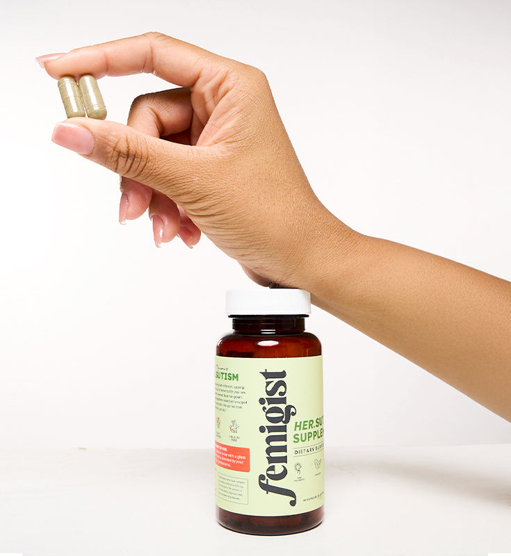 Femigist Her.sutism Supplement – Woman holding capsules next to the bottle, a natural solution for reducing facial hair.
